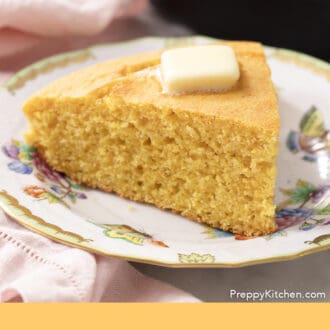 Pinterest graphic of a piece of cornbread in front of an iron skillet.