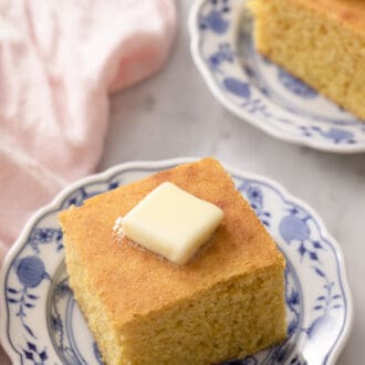 Two pieces of cornbread on blue and white plates.