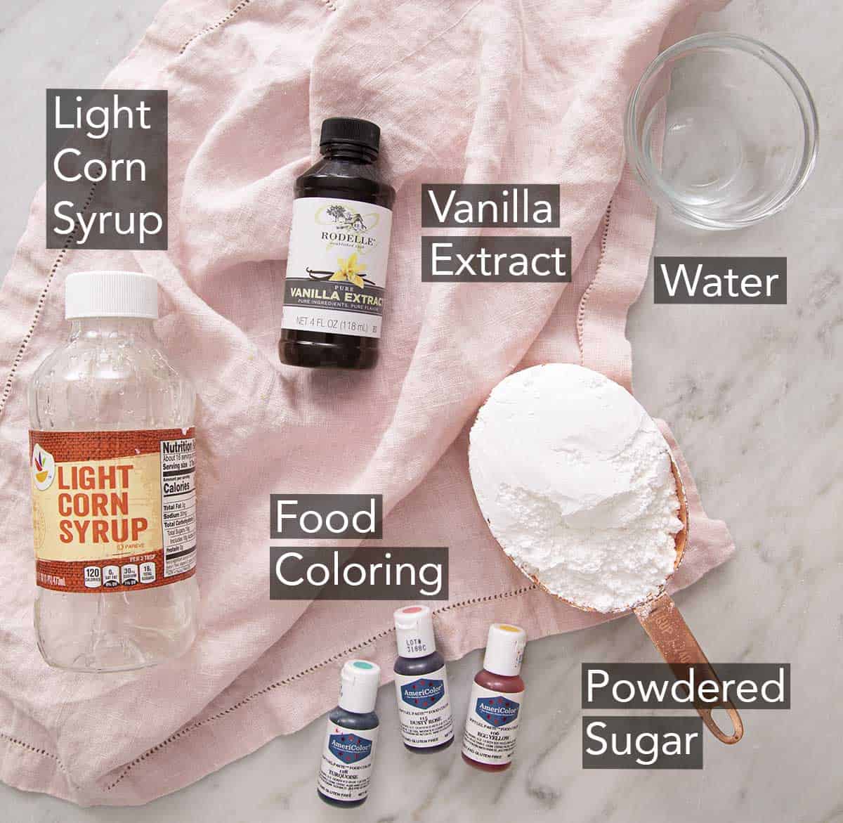 Ingredients to make sprinkles on a marble counter.