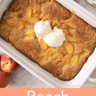A baking dish filled with peach cobbler topped with vanilla ice cream..