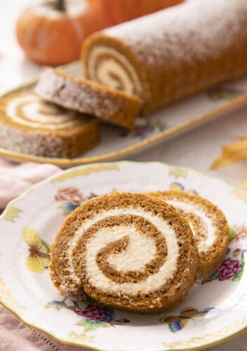 Two pieces of a pumpkin roll cake on a plate.