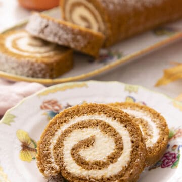 Two pieces of a pumpkin roll cake on a plate.