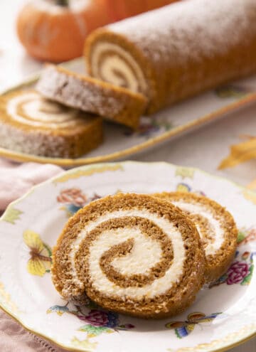 Two pieces of a pumpkin roll cake on a plate.