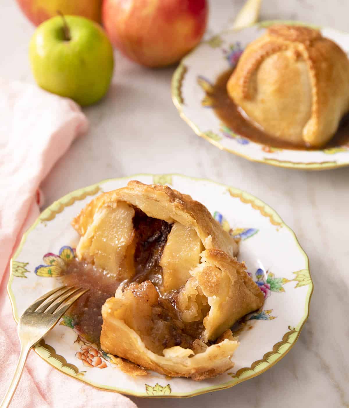 A cut open apple dumpling in a pool of brown sugar sauce.