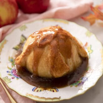 An apple dumpling dripping with brown sugar sauce.