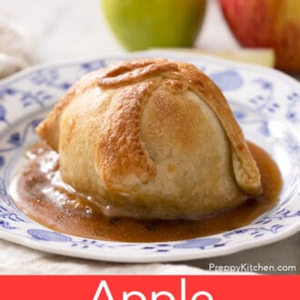 An apple dumpling on a blue and white plate with syrup.
