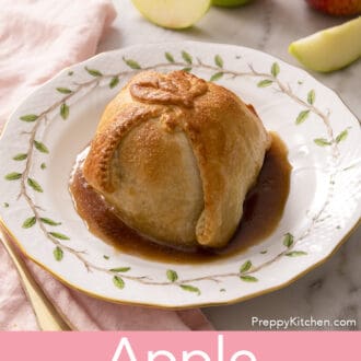An apple dumpling on a white plate with syrup.