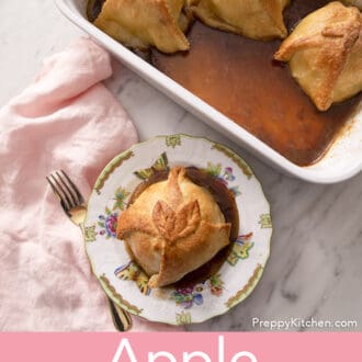An apple dumpling on a plate next to a pink linen napkin.