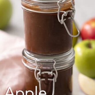 Two jars of apple butter stacked on a counter.
