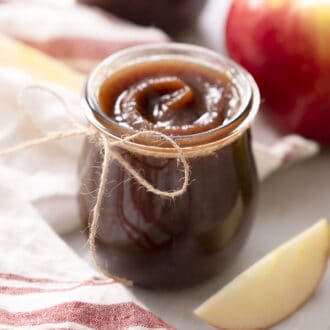 Apple butter in a glass jar tied with twine.