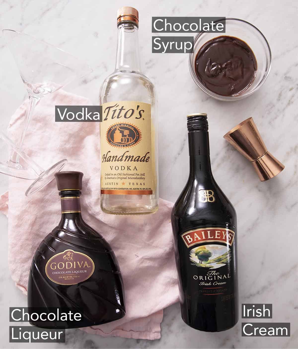 Ingredients to make a chocolate martini on a marble counter.