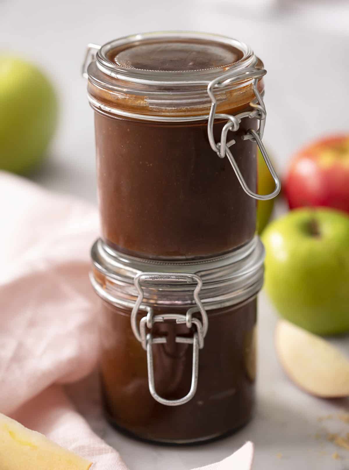 Two stacked mason jars filled with apple butter.
