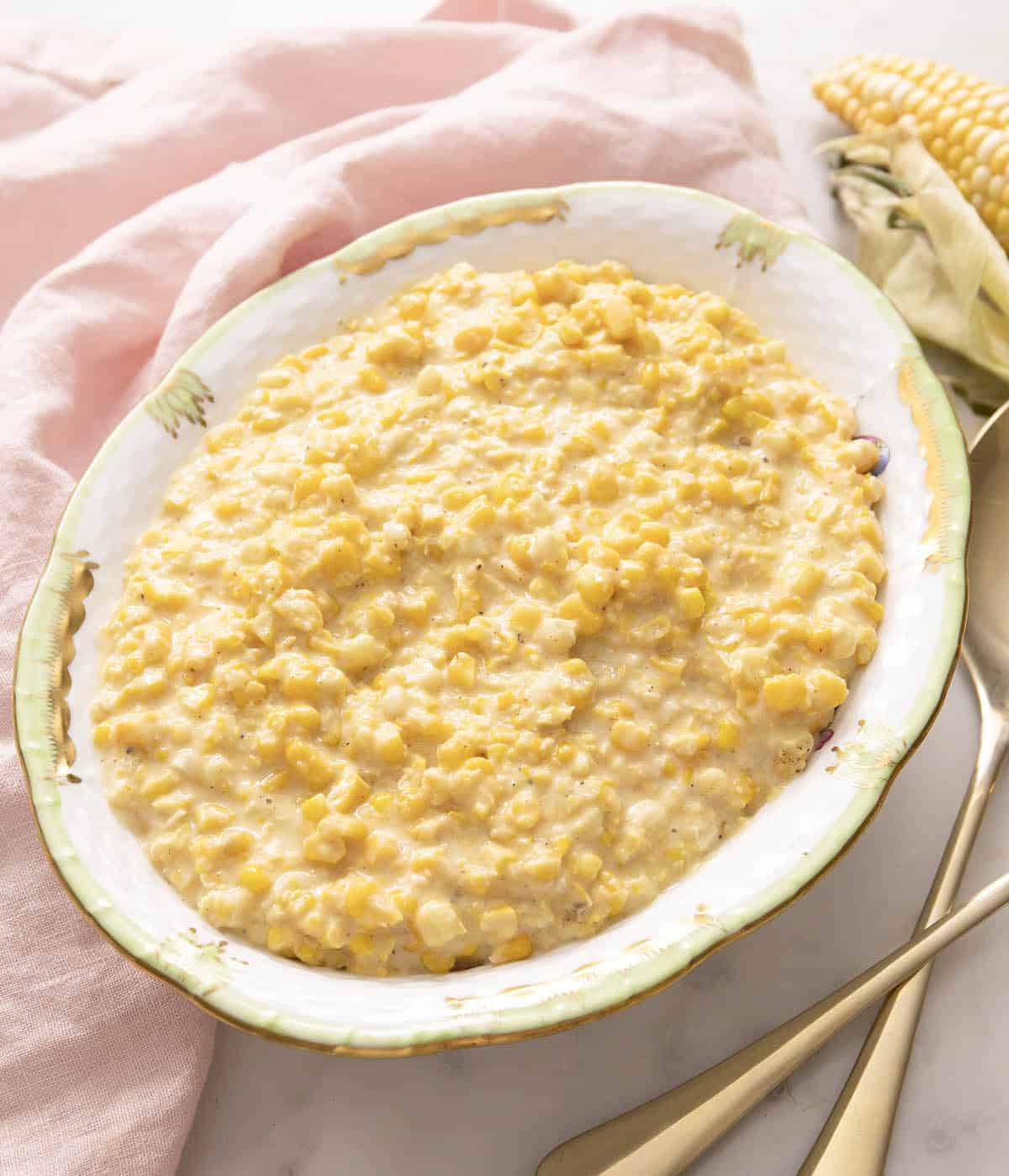 Creamed corn in a porcelain serving bowl.