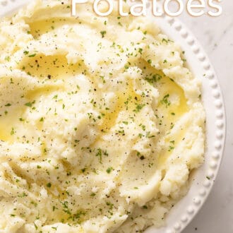 Pinterest graphic of an overhead view of mashed potatoes in a bowl topped with chopped herbs.