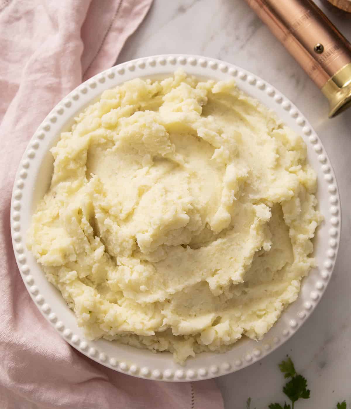 Fluffy mashed potatoes in a round serving dish.