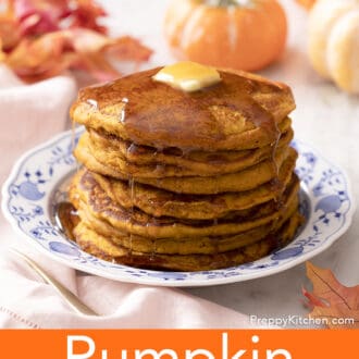 A stack of pumpkin pancakes with syrup and butter.