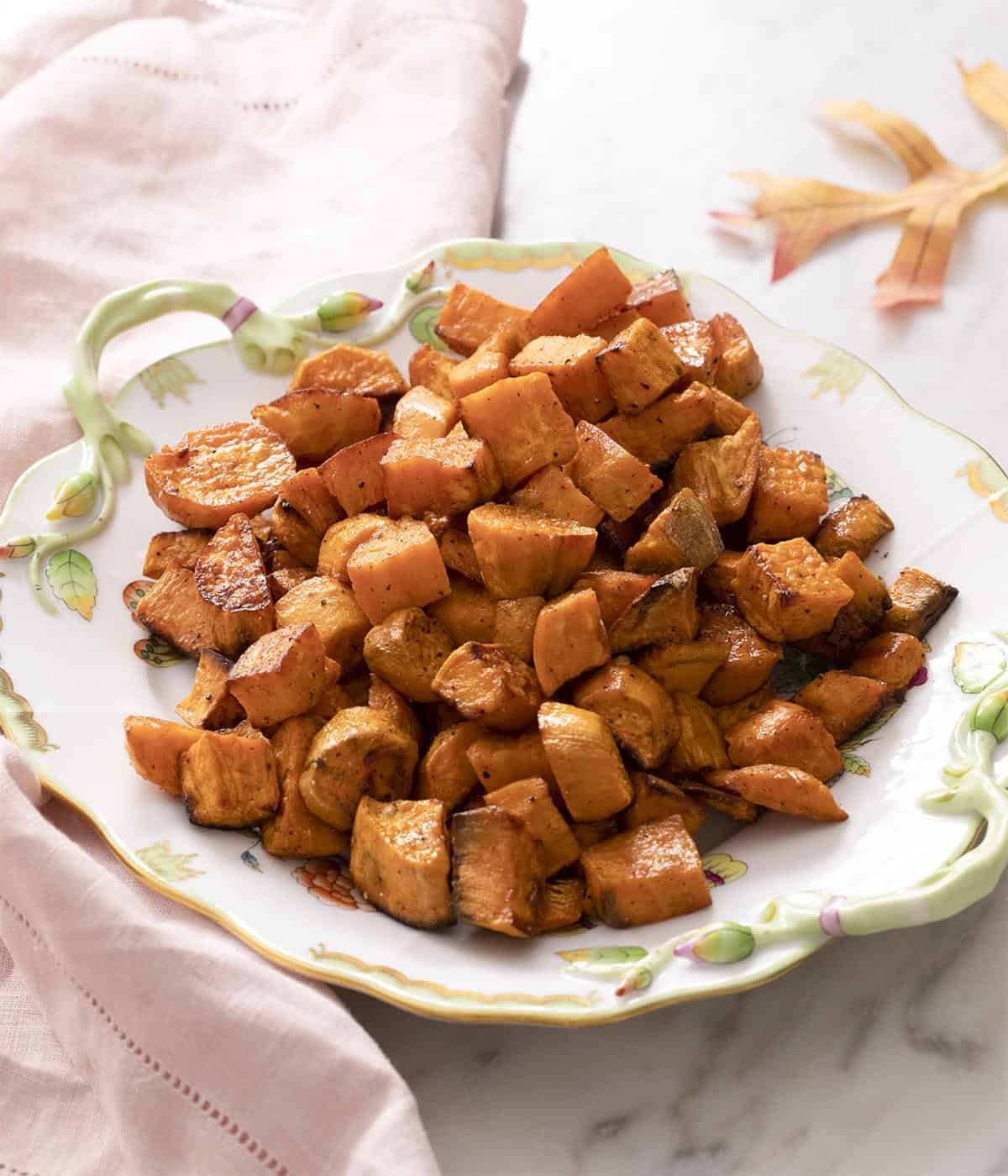 Roasted sweet potatoes on a white serving dish.