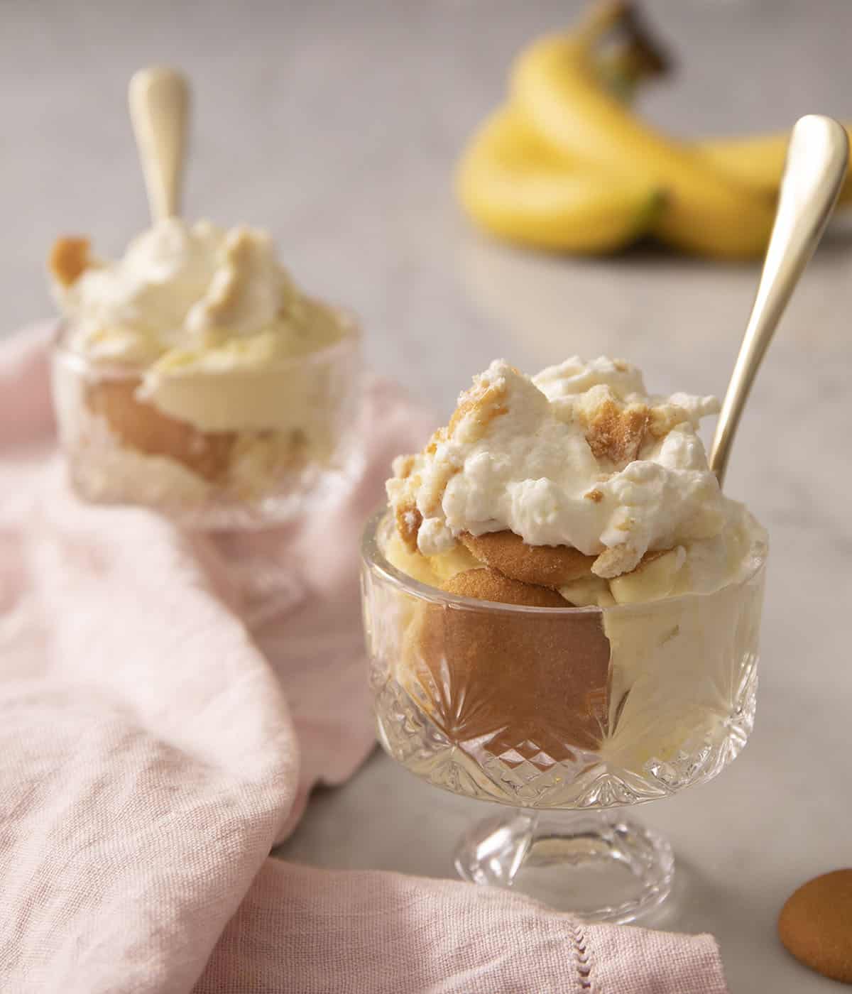 Two servings of banana pudding in crystal glasses.