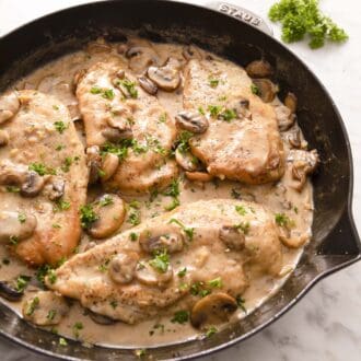 A large iron skillet filled with chicken marsala.