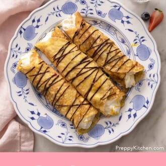 rolled crepes on a plate with chocolate drizzle