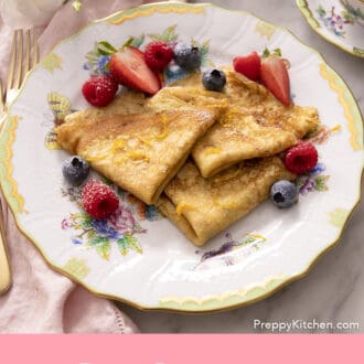 Pinterest graphic of folded crepes on a plate with berries.