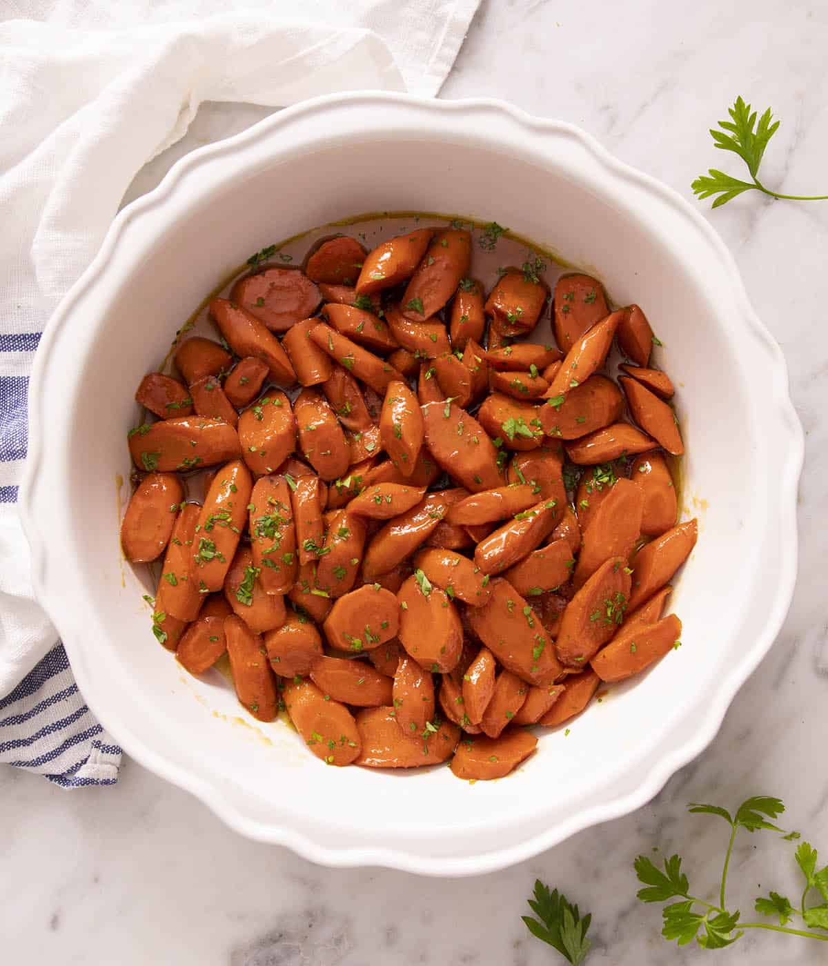 Glazed carrots in a round white dish.