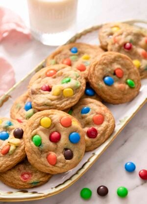 A group of M&M cookies on a porcelain serving tray.