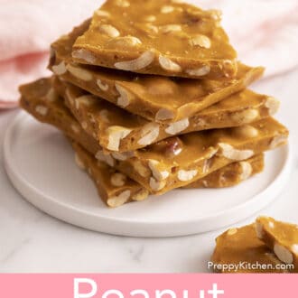 pieces of peanut brittle stacked on a white plate