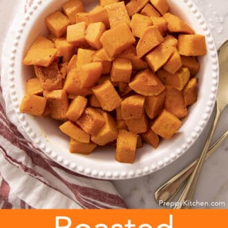 A round white serving with with cubes of roasted butternut squash.