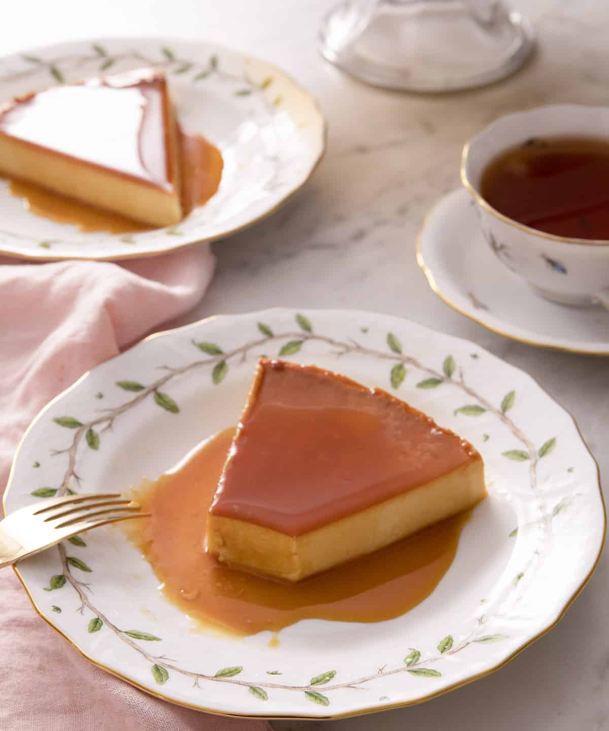 A piece of flan on a plate with a bite taken out.
