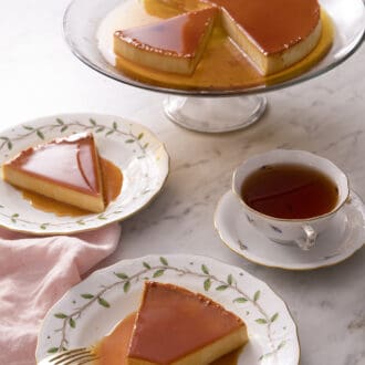 flan on a white plate with a fork and a white marble counter