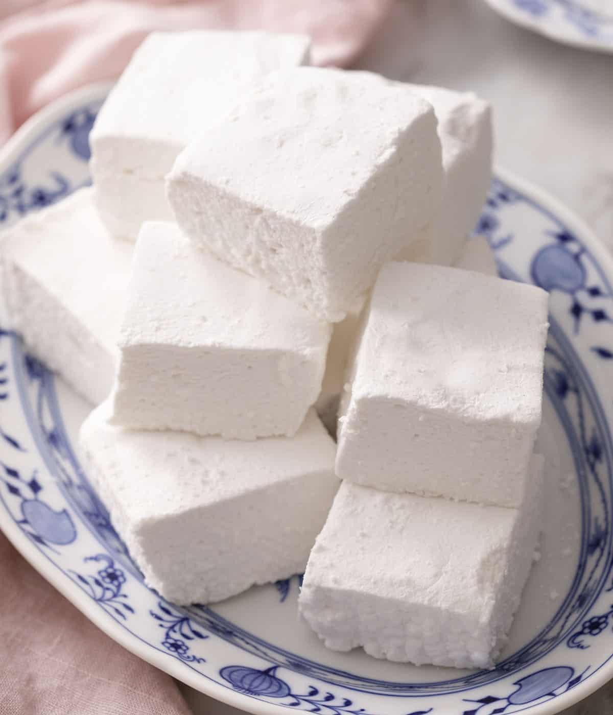 A pile of marshmallows on a blue and white serving dish.