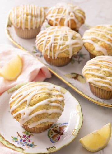 A group of lemon poppy seed muffins on blue and white plates.