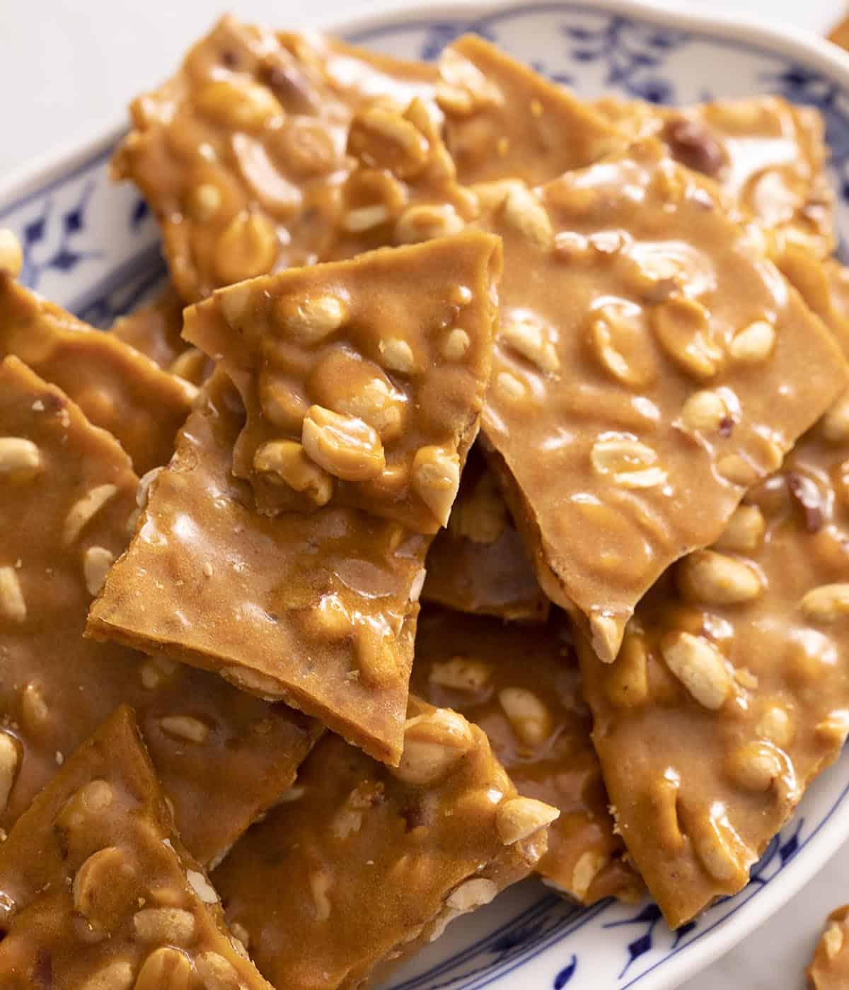 Peanut brittle in a blue and white serving dish. 