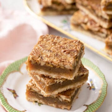 Three pecan pie bars on a small plate.