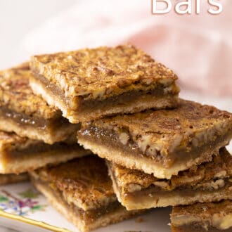 pecan pie bars stacked on a serving tray