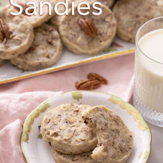 pecan sandies stacked on a plate with a glass of milk