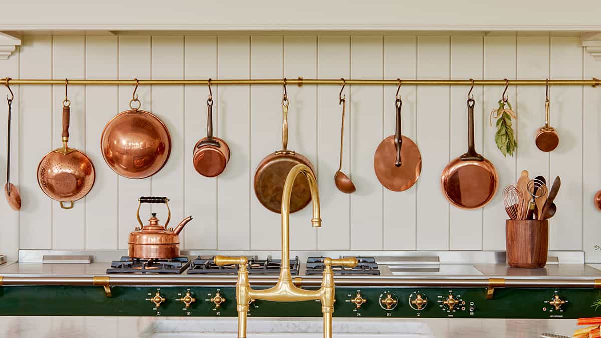 A photo of John's Kitchen with a group of copper pots displayed on the wall.