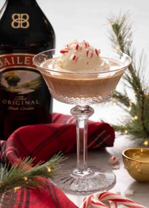 A Baileys affogato in a crystal glass with crushed candy cane on top.