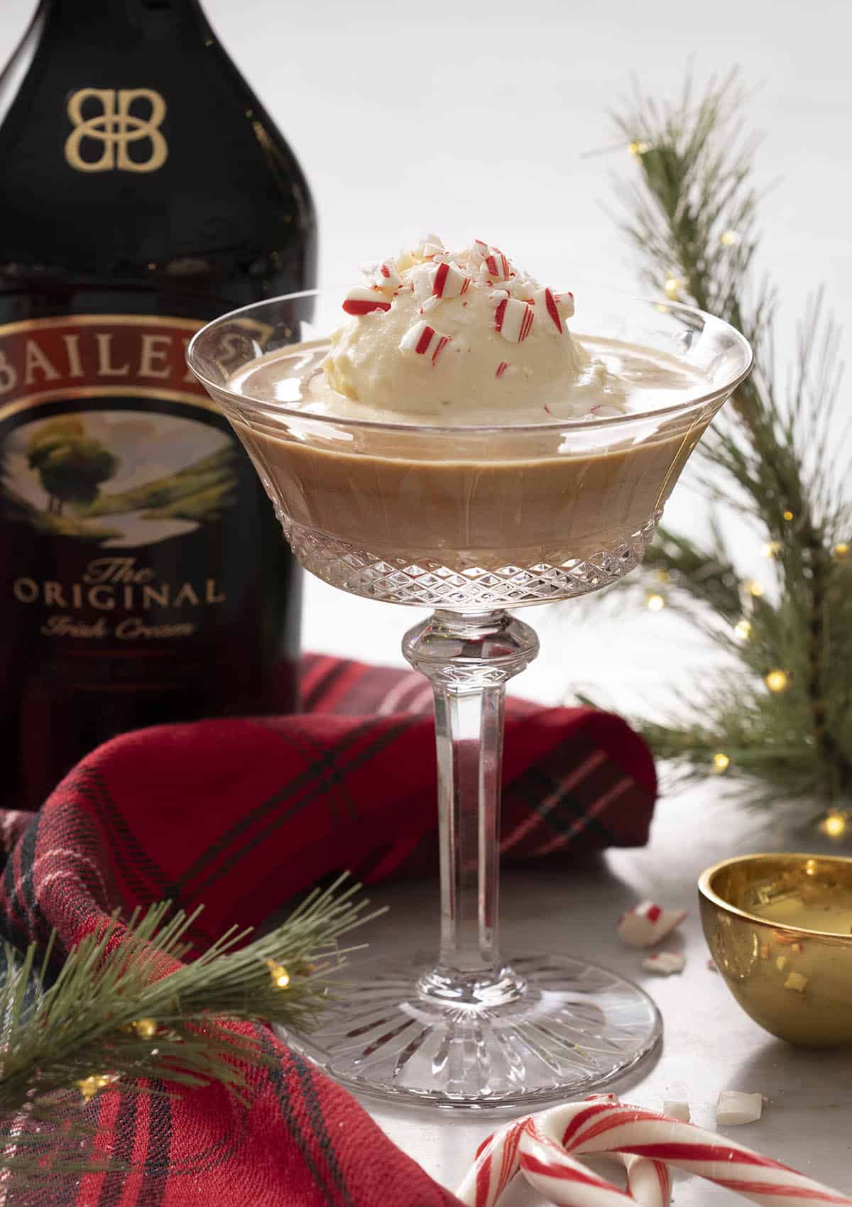 A Baileys affogato in a crystal glass with crushed candy cane on top.