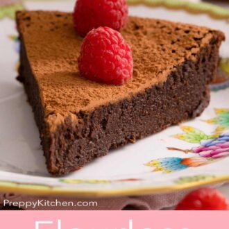 A pinterest graphic of a slice of flourless chocolate cake with two raspberries on top.