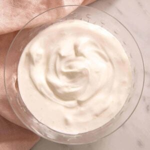 A close up of the result of the how to make sour cream tutorial in a glass bowl.