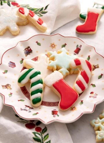 A side shot of Christmas sugar cookies with icing on a plate