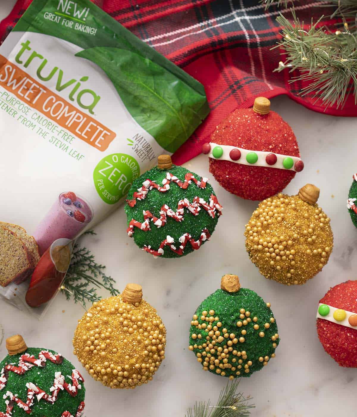 A bag of Truvia Sweet Complete next to some cupcakes decorated as Christmas ornaments.