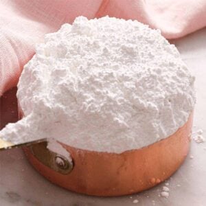 A close up of powdered sugar in a measuring cup