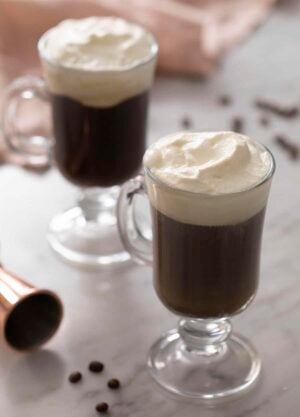 Two Irish coffees topped with whipped cream