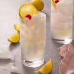 a tom collins cocktail in a glass with ice