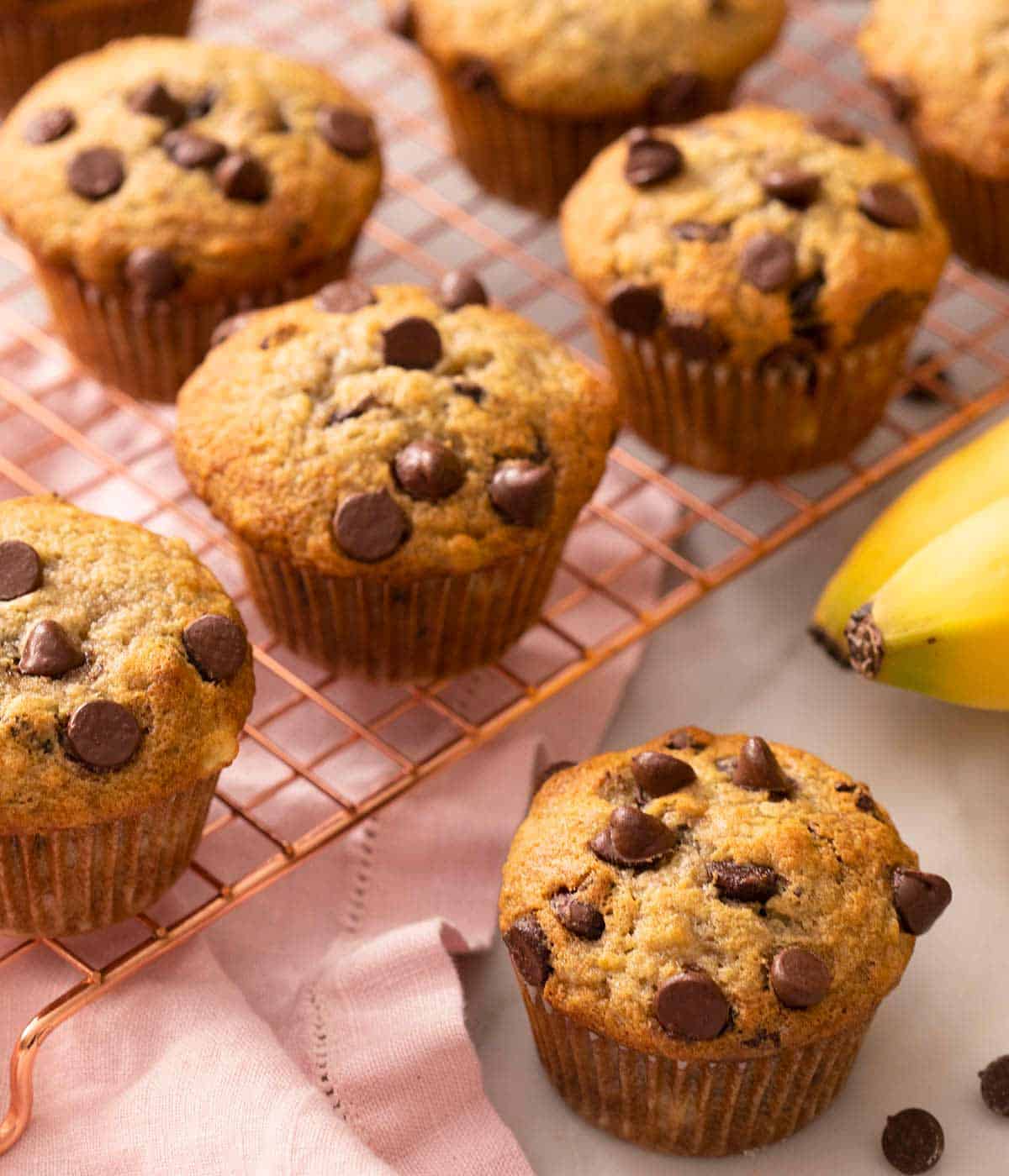 A close up of banana chocolate chip muffins on a cooling rack