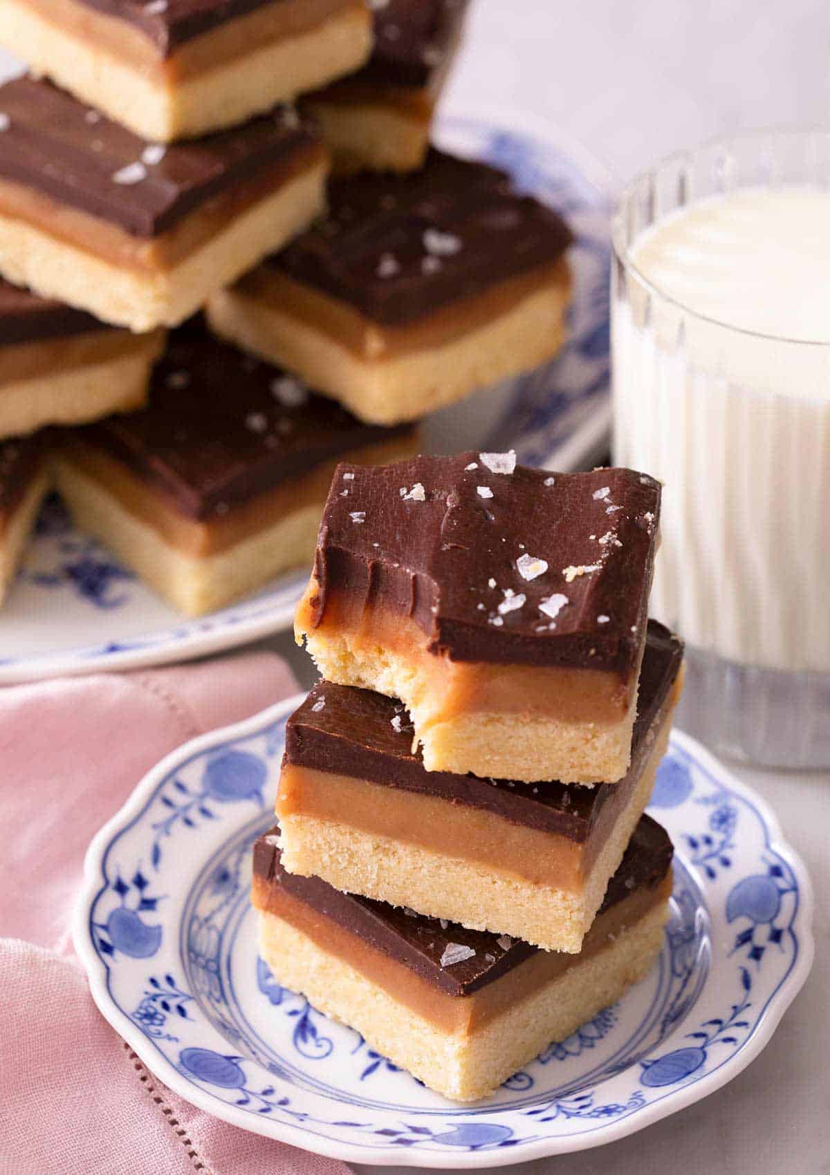 Three Millionaire's shortbread stacked on top of each other one with a bite out