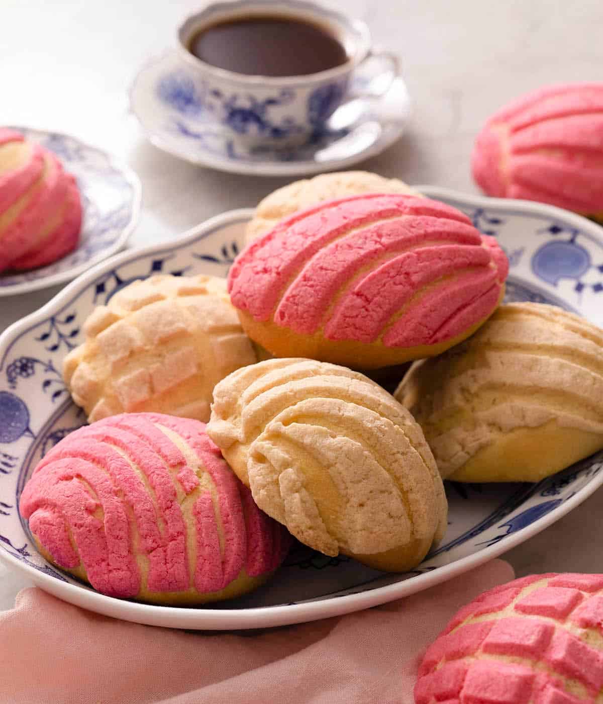 Pan Dulce on a blue serving plate with a cup of coffee in the background